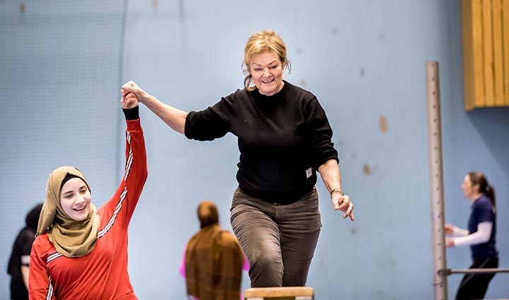 Forskaren Marie Öhman assisterar elev under hinderbana i gymnastiksalen