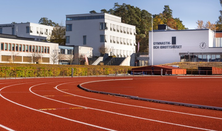 Gymnastik och idrottshuset med löparbanor i förgrunden.