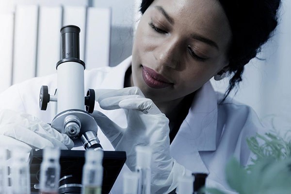 Kvinnlig forskare med mikroskop