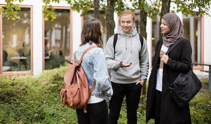 Tre studenter som pratar med varandra.