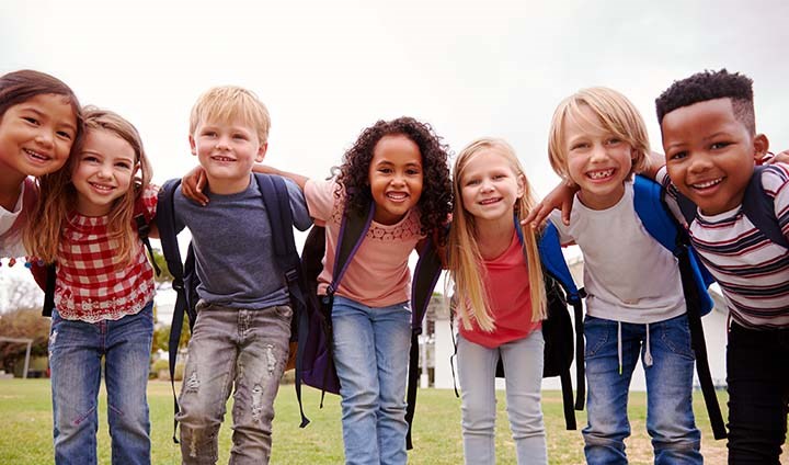young children smiling and having their arms around each other