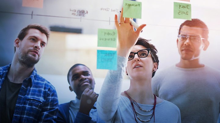 Människor som tittar på en skärm vända mot oss.