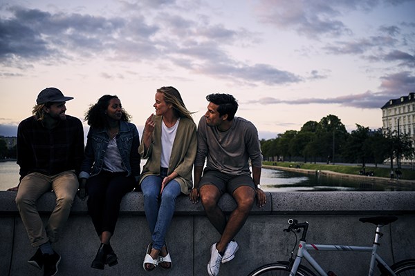 Studenter sitter på en bro med cyklar