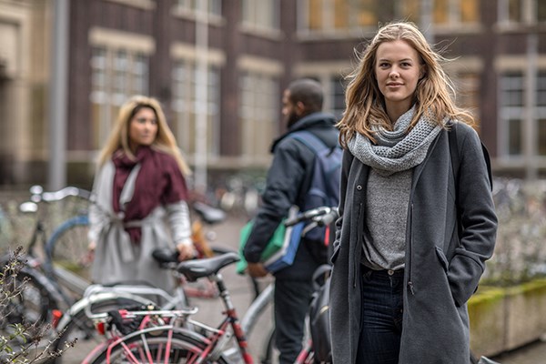 Tjej vid sin cykel på hösten