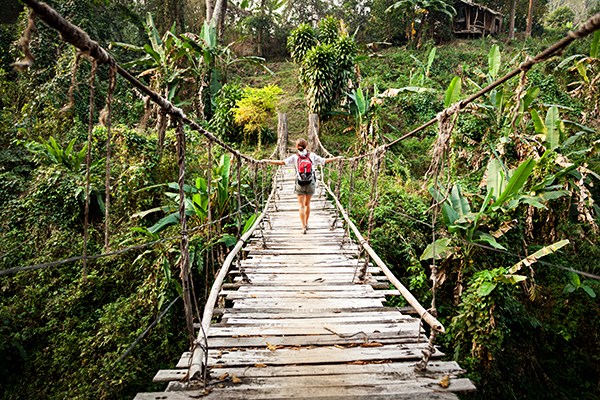Tjej på en bro i djungeln