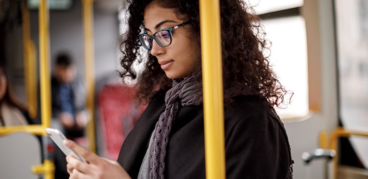 Tjej på buss kollar mobilen