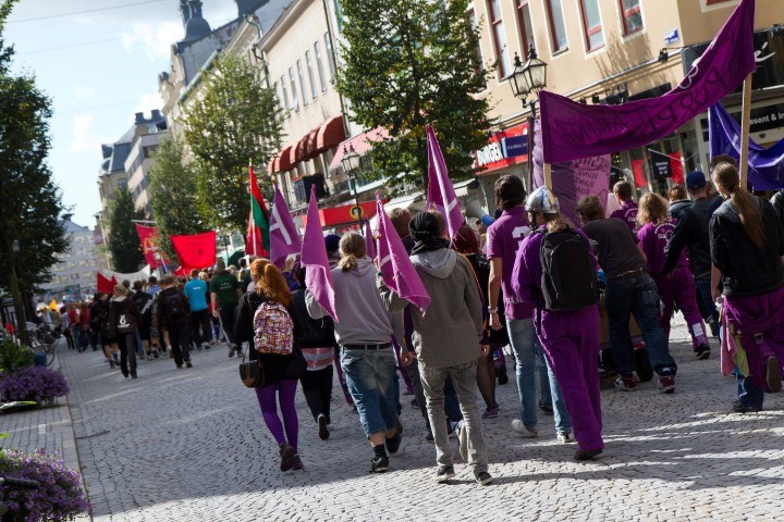 Studenter vandrar i led nerför en gata i centrum.