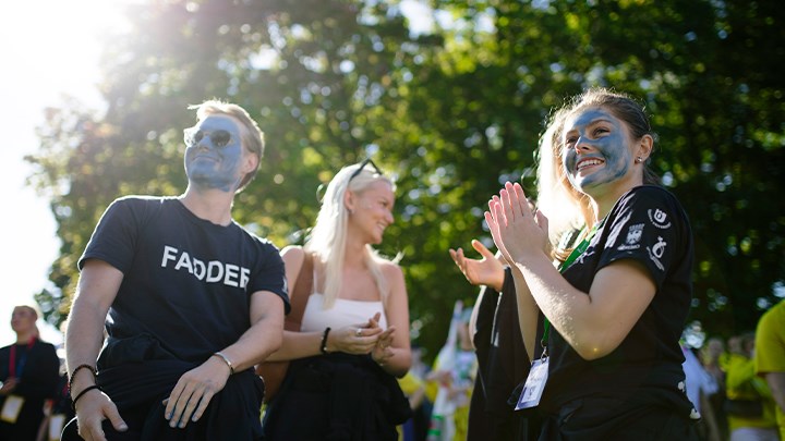 Studenter som står utomhus och hejar på sitt lag