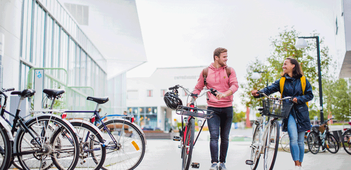 Studenter leder cyklar på campus