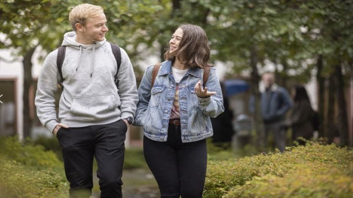 två personer på promenad som pratar med varandra