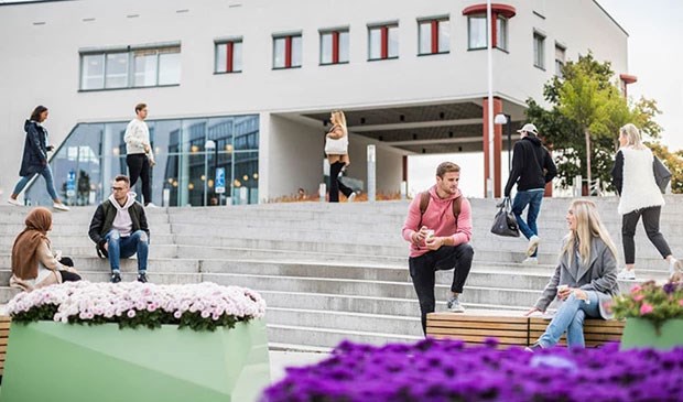 Flera studenter utanför en av universitetets byggnader.