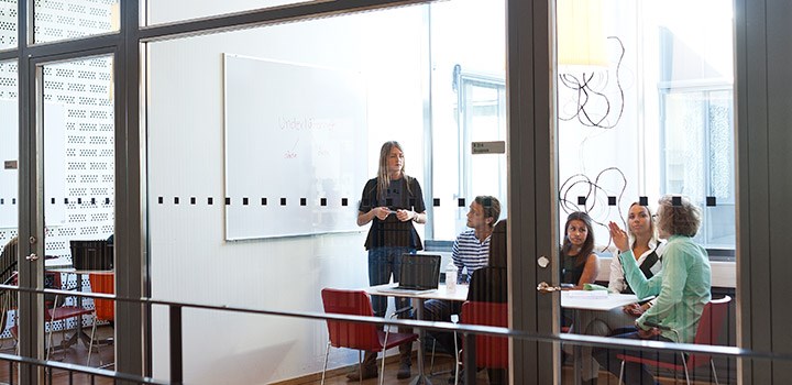 En grupp studenter sitter i ett grupprum och samtalar