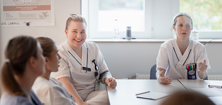 Fyra sjuksköterskestudenter sitter runt ett bord.