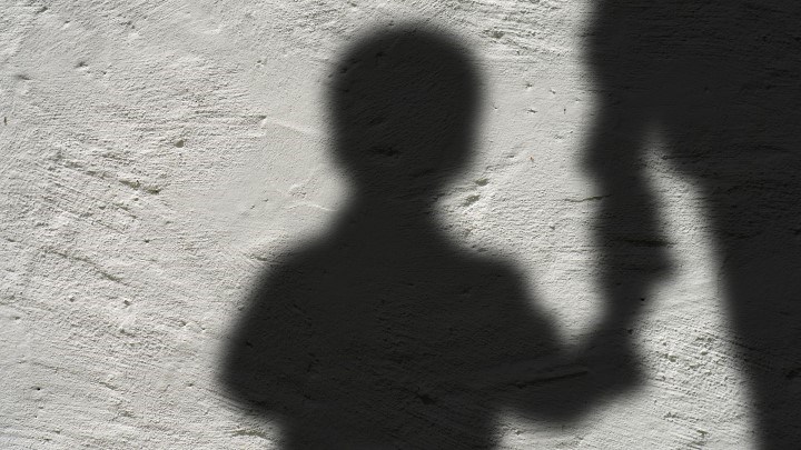 Skuggbild av ett barn och vuxen hand i hand