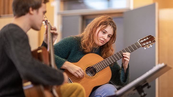 Två personer som spelar gitarr.