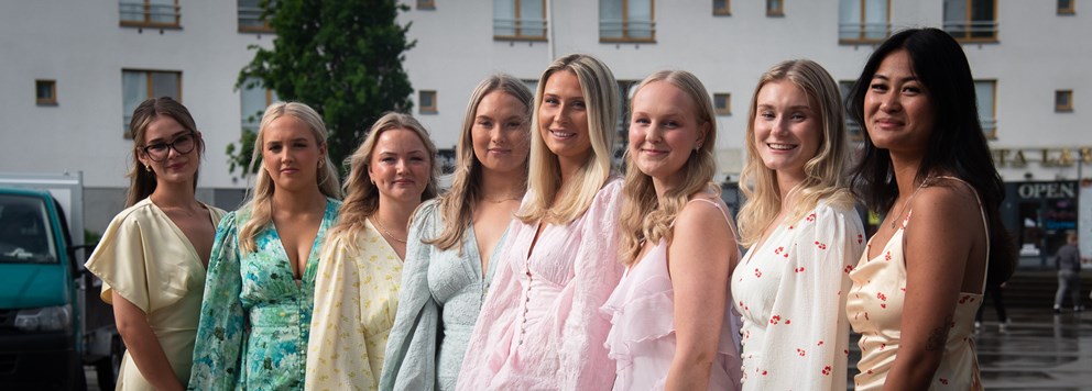 Åtta glada studenter som tagit examen.
