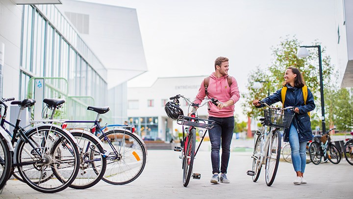 Studenter leder cyklar på campus