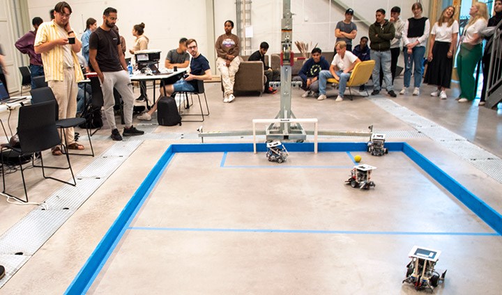 Football game between robots in progress. Each robot team consists of three players.