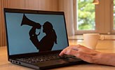 A computer. On the screen is a woman screaming in a megaphone.