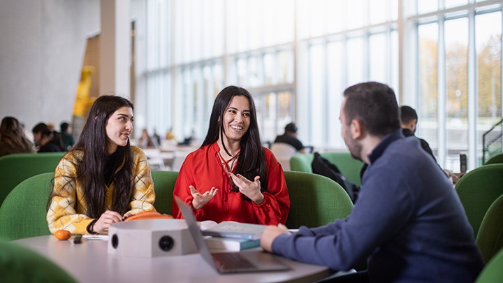 Tre studenter i samtal.