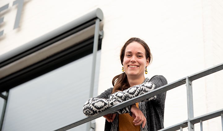 Alina Koch, smiling and standing on a balcony.